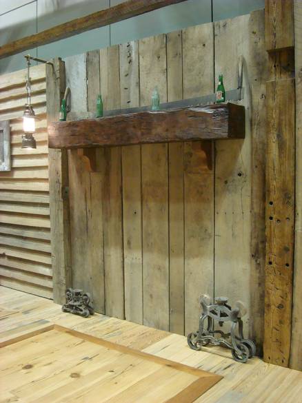 hand-hewn mantel mounted at the home show / barnwood planks behind w/ antiques