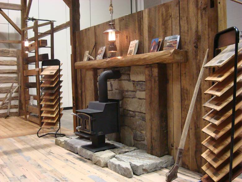 barnwood wall with stone hearth, flooring displays / Antique wood burning stove, lantern lights
