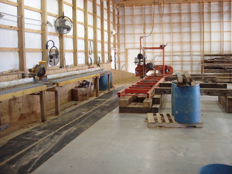 Wood-Mizer and end-cut station / The concrete floor is hard--they have put down rubber runners