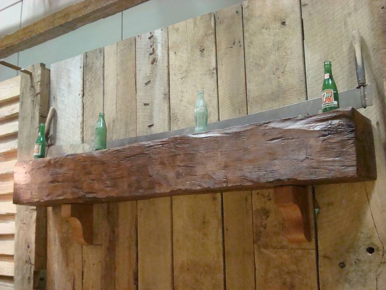 close-up of hand-hewn mantle / wax finished w/ antique bottles & barnwood behind